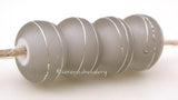 Gray White Heart With Fine Silver A gray white heart bead wrapped with strands of fine silver. 5x12 mm price is per bead Glossy,Matte