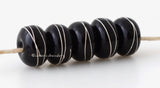 Black Silver Wraps #2019 6x11 mm5 BeadsHole Size: 2.5 mm~ All black fine silver wrapped beads. The fine silver is burnished to the glass bead while still hot in the flame. ~ This lampwork glass bead set is ready to ship. Default Title