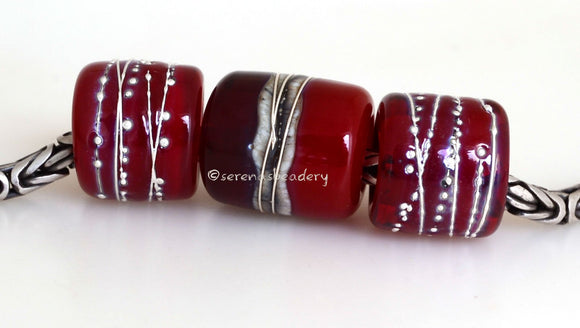 Red Hot Tube Beads Size: 11x13 & 15x13 mm Amount: 3 Beads Hole Size: 5 mm Two matching translucent red fine silver decorated tube beads and one red two-toned bead with silvered ivory and more fine silver.  Default Title