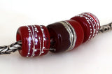 Red Hot Tube Beads Size: 11x13 &amp; 15x13 mm Amount: 3 Beads Hole Size: 5 mm Two matching translucent red fine silver decorated tube beads and one red two-toned bead with silvered ivory and more fine silver.  Default Title