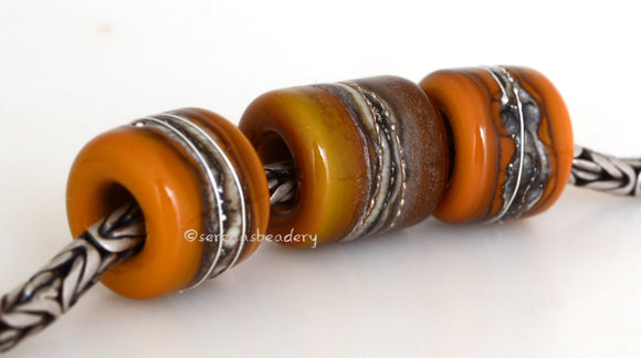 Rock Bluff Euro Charms #2063 11x12 & 14x12 mm3 BeadsHole Size: 5 mm~ Two matching butternut orange tube beads and one butternut and chocolate brown bead with silvered ivory and fine silver. ~ These lampwork glass beads are ready to ship. Default Title