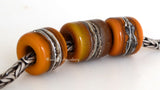 Rock Bluff Euro Charms #2063 11x12 &amp; 14x12 mm3 BeadsHole Size: 5 mm~ Two matching butternut orange tube beads and one butternut and chocolate brown bead with silvered ivory and fine silver. ~ These lampwork glass beads are ready to ship. Default Title
