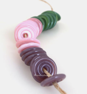 Make It Up #2107 Green, pink, and mauve spiral wavy disks3x14 mm18 BeadsHole Size: 2.5 mm These lampwork glass beads are ready to ship. Default Title