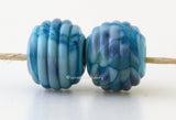 River Dance Ribbed Pair #2086 A pair of round ribbed lampwork glass beads in turquoise blue with different shades of blue frit.~~~~~~~~~~~~~~~~~~~~~~~~~~9x12 mm2 Beads2.5 mm hole These lampwork glass beads are ready to ship. Default Title