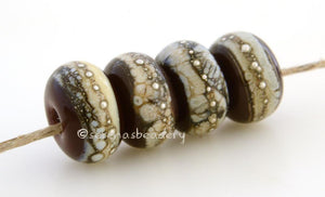 Dark Brown Granite with Fine Silver Dark brown wrapped in silvered ivory and fine silver droplets. 5x11 mm 2.5 mm hole Price is per bead with discounts for larger quantities. Glossy,Matte