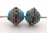 Turquoise Raku Ribbed Bicones #1718 Size: 8x13 mm ~ Amount: 2 Beads ~ Hole Size: 2.5 mm~ Turquoise blue and raku in a ribbed bicone shape in a matte finish. ~These beads are ready to ship. Default Title