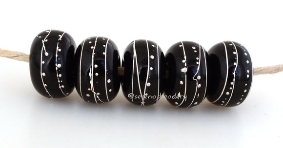 Black Fine Silver Extra 7x12 mm5 BeadsHole Size: 2.5 mm~ All black beads with an extra amount of fine silver. The fine silver is burnished to the glass bead while still hot in the flame. ~ This lampwork glass bead set is ready to ship. Default Title