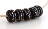 Black Fine Silver Extra 7x12 mm5 BeadsHole Size: 2.5 mm~ All black beads with an extra amount of fine silver. The fine silver is burnished to the glass bead while still hot in the flame. ~ This lampwork glass bead set is ready to ship. Default Title