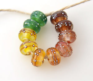 Wispy Rainbow Silver Dots #1819 6x12 mm10 BeadsHole Size: 2.5 mm~ A set of wispy rainbow fine silver wrapped dot beads in green, yellow, orange, red, and deep red. The silver droplets have been carefully burnished onto the glass bead while it is still hot to ensure that it has permanently adhered to the bead. ~ This lampwork glass bead set is ready to ship. Default Title