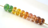 Wispy Rainbow Silver Dots #1819 6x12 mm10 BeadsHole Size: 2.5 mm~ A set of wispy rainbow fine silver wrapped dot beads in green, yellow, orange, red, and deep red. The silver droplets have been carefully burnished onto the glass bead while it is still hot to ensure that it has permanently adhered to the bead. ~ This lampwork glass bead set is ready to ship. Default Title