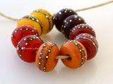 Fall Harvest Fall Harvest colors with fine silver droplets. Choose one pair or the set of 10 beads. The colors are brown, red, deep orange, light orange, and bright yellow.Bead Size: 6x11 mmAmount: 2 or 10 BeadsHole Size: 2.5 mm Glossy,Brown,Glossy,Red,Glossy,Deep Orange,Glossy,Light Orange,Glossy,Yellow,Glossy,Set of 5 Pairs,Matte,Brown,Matte,Red,Matte,Deep Orange,Matte,Light Orange,Matte,Yellow,Matte,Set of 5 Pairs