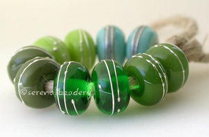 Fine Silver Greens A set of green colored lampwork beads with 5 different pairs. From top left going counter-clockwise - copper green, pea green, olive, emerald, and mystic green. Each silver wrap is carefully burnished onto the glass bead while it is still hot. Bead Size: 6x11 mm Amount: 10 Beads Hole Size: 2.5 mm Also available in a 7x14 mm size for .00 extra. Glossy,6x11mm,Glossy,7x14mm,Matte,6x11mm,Matte,7x14mm