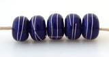 5 Dark Cobalt Blue Fine Silver Wire Wraps Dark cobalt blue wrapped with fine silver wire. The silver sire has been carefully burnished onto the glass bead while it is still hot to ensure that it is permanently adhered to the bead.~~~~~~~~~~~~~~~~~~~~~~~~~~6x11, 12 or 7x13 mm5 Beads2.5 mm hole Glossy,11 mm,Glossy,12 mm,Glossy,13 mm,Matte,11 mm,Matte,12 mm,Matte,13 mm