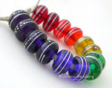 Rainbow Silver Wrapped Rondelle Set A set of rainbow rondelles pairs wrapped in fine silver. The colors range from red, orange, yellow, green, blue, indigo, and violet. Since the violet is so dark it is layered over white. 6x11mm price is per set of 14 beads Glossy,Matte