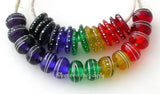 Rainbow Silver Wrapped Wavy Disc Set A set of rainbow wavy disk pairs wrapped in fine silver. The colors range from red, orange, yellow, green, blue, indigo, and violet. 3x14mm price is per set of 14 beads Glossy,Matte
