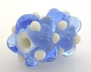 Blue Pearl Wovens A pair of wovens in transparent blue with pearly colored accents.These woven beads are a very intricate and unique design with lots of texture. These are all one color for plenty of sparkle.7x13 mmprice is per pair of beads Glossy,Matte