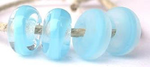 Dark Sky Blue Ribbon Color Notes: dark sky blue ribbon cased in clear 5x10 mm Donut- This is my basic spacer size. It is made on a 3/32 mandrel with a 2.5 mm hole. Other available sizes and shapes: 4x8 mm Round- A miniature sized spacer with a 1.5 mm hole. Lentil- 12x13 mm in size with a 1.5mm hole. Pillow- 14 mm square with a 1.5 mm hole. Disk- 3x13 mm with a 2.5 mm hole. Also 6x12 mm donut- A larger donut with a 2.5 mm hole. 8x15 mm Super Sized- A humungous spacer with a 3.5 mm hole. It is perfect for str
